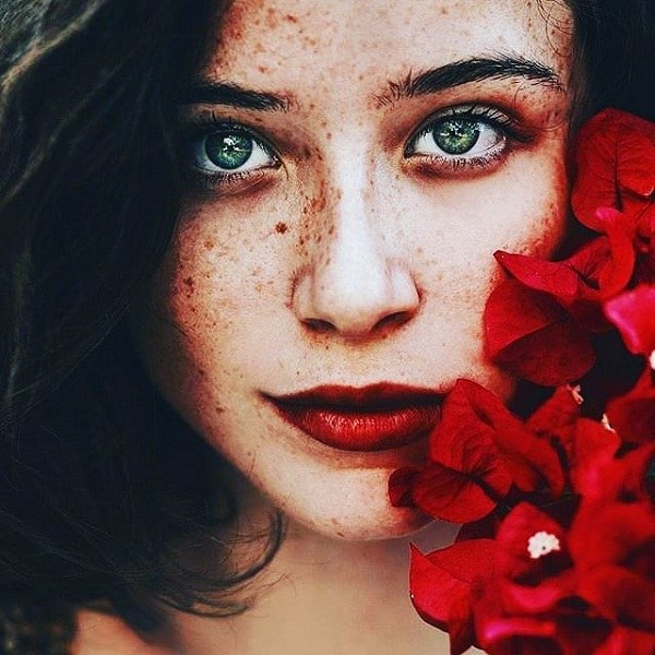 عکس دختر چشم سبز با گل قرمز
